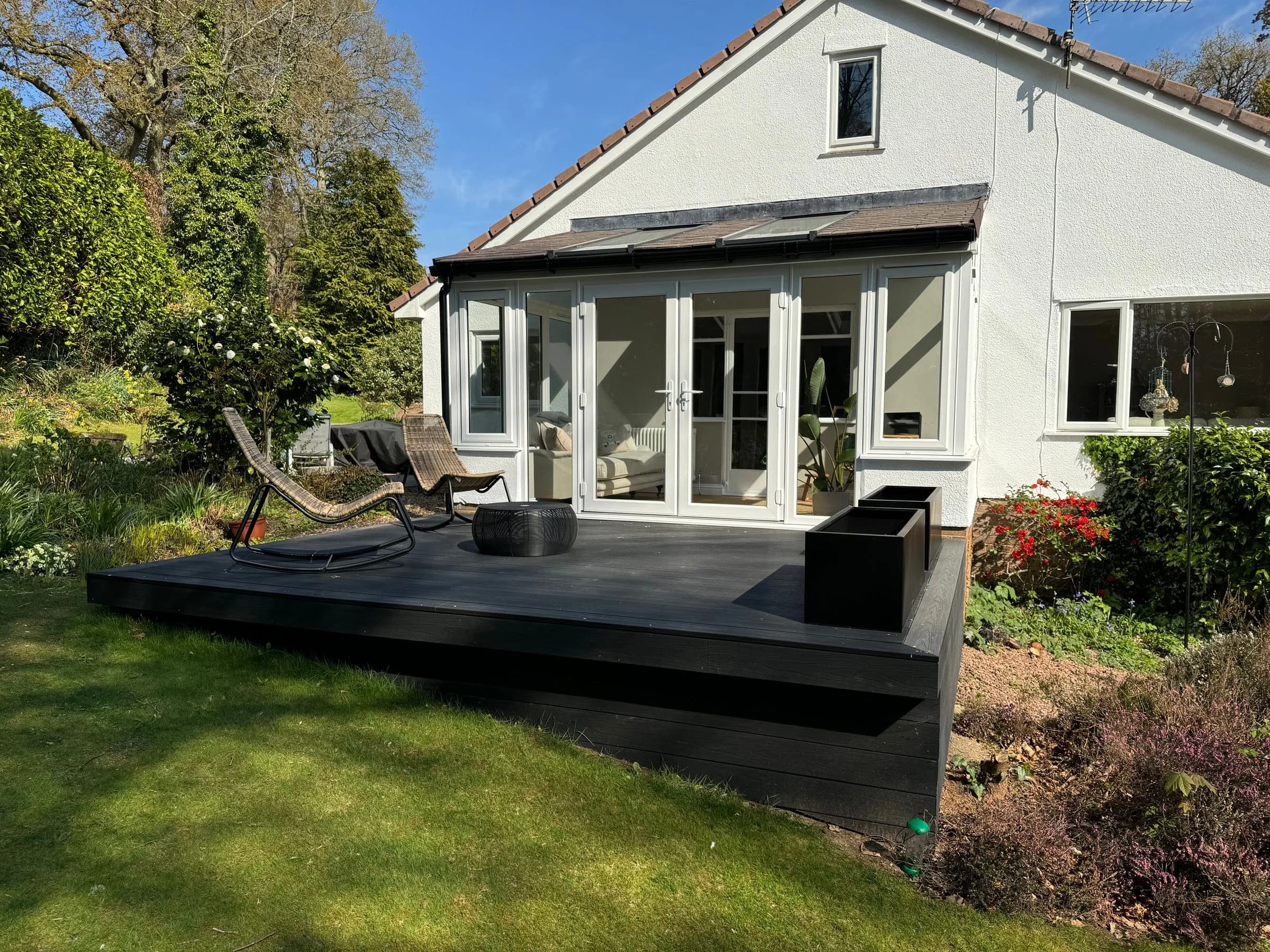 SupaLite lightweight tiled conservatory roof on a garden room, seen across the lawn from the end of the decking.